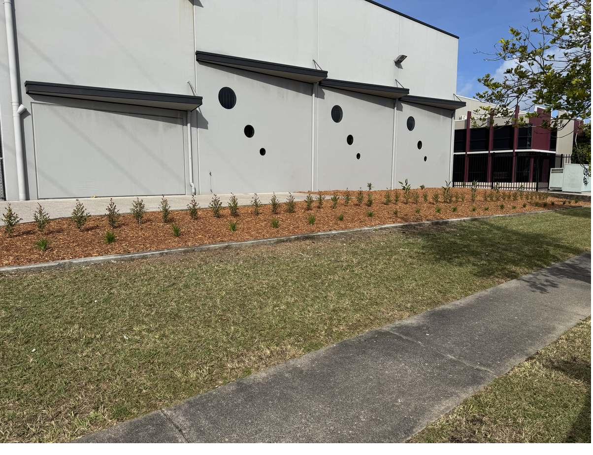 Finished garden bed and edged turf verge along an industrial frontage at Warana