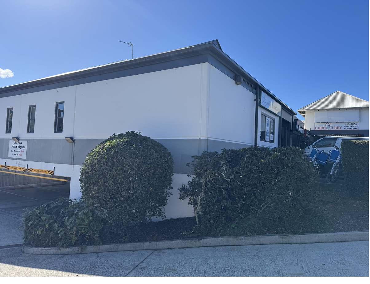 Hedge cut back to shape and bed cleared at a Mooloolaba commercial building corner