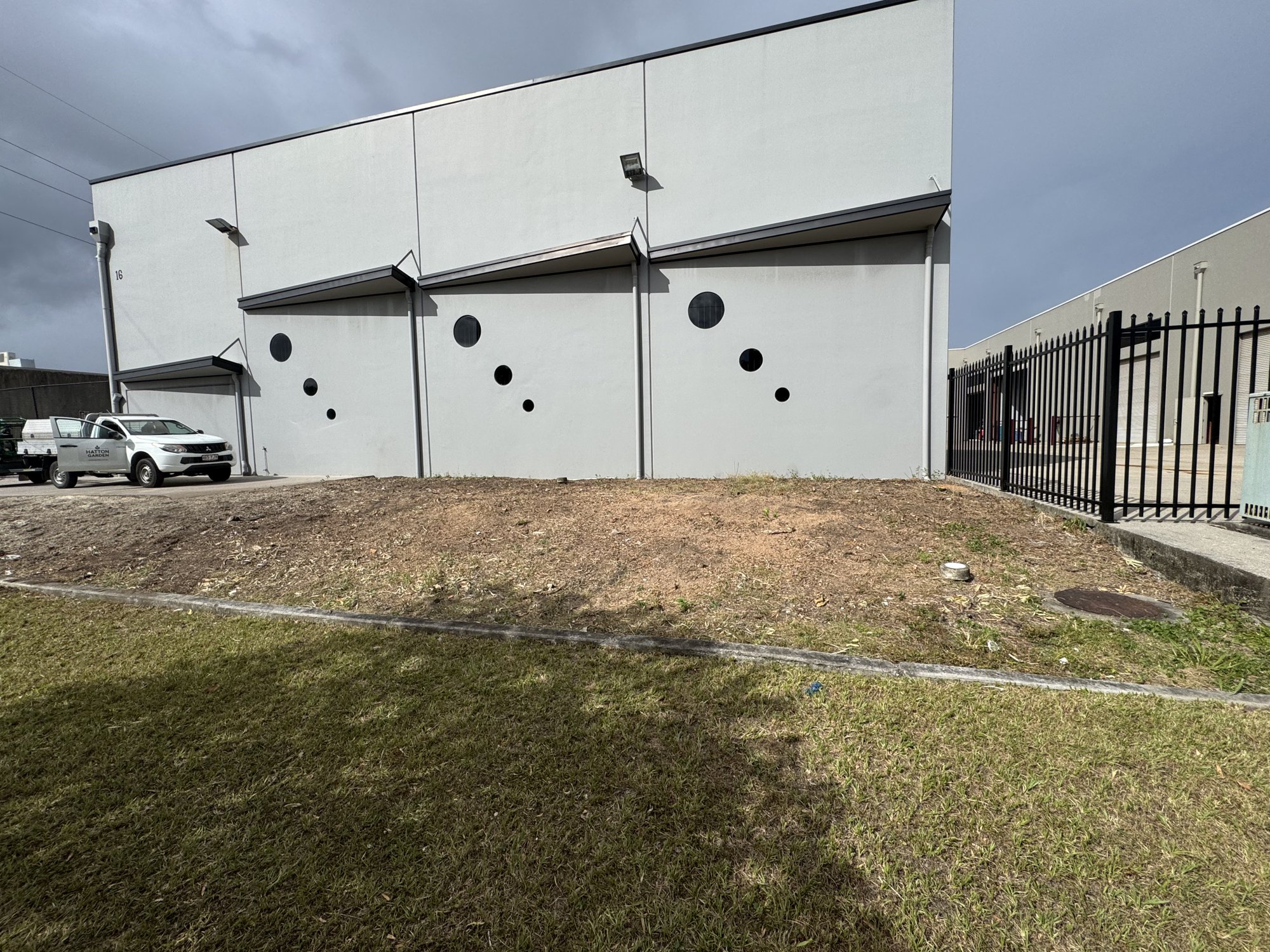 Industrial unit frontage before garden bed installation, front angle