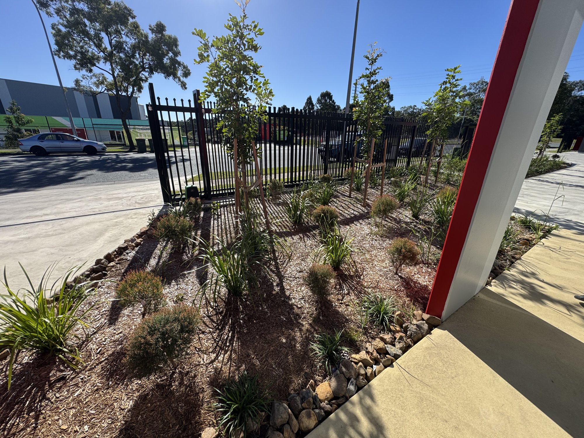 Pebble-edged native garden bed at an industrial estate gate